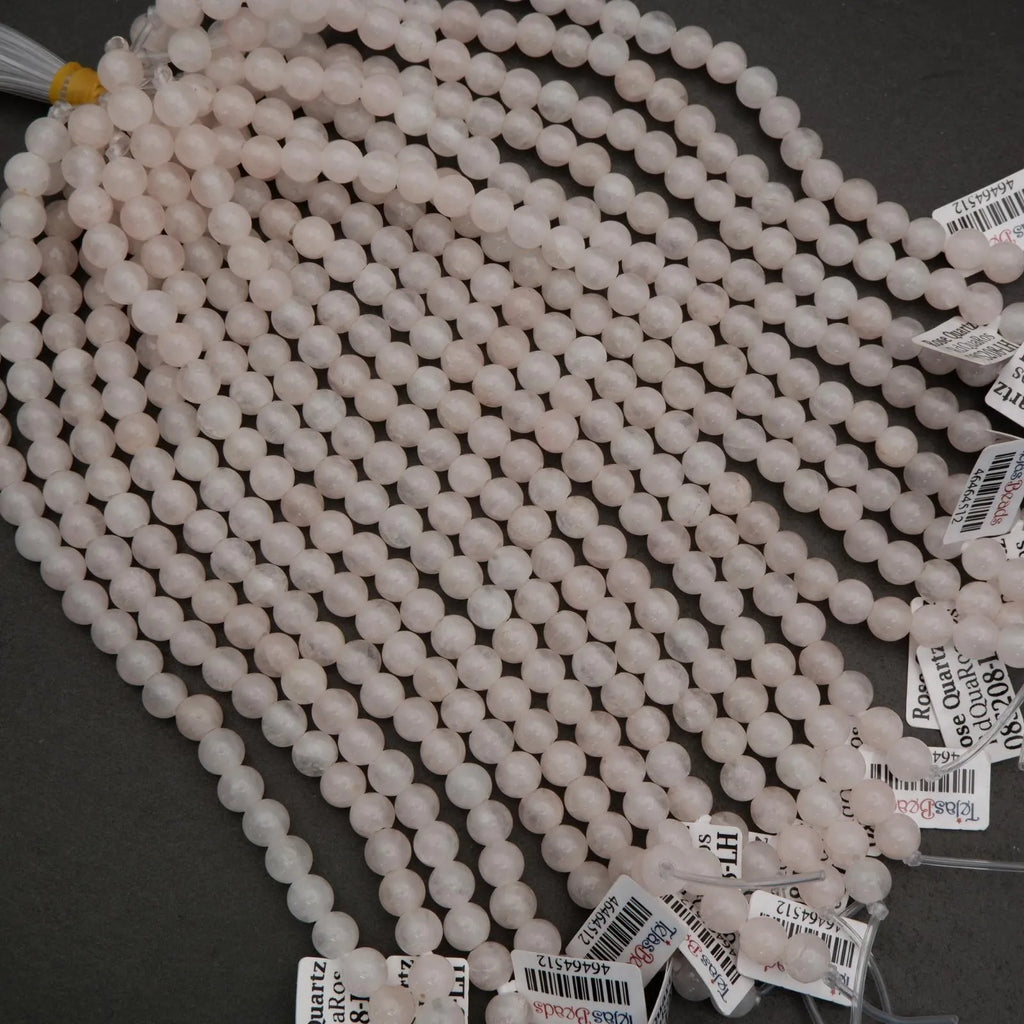 String of pink beads with price tags on a dark surface