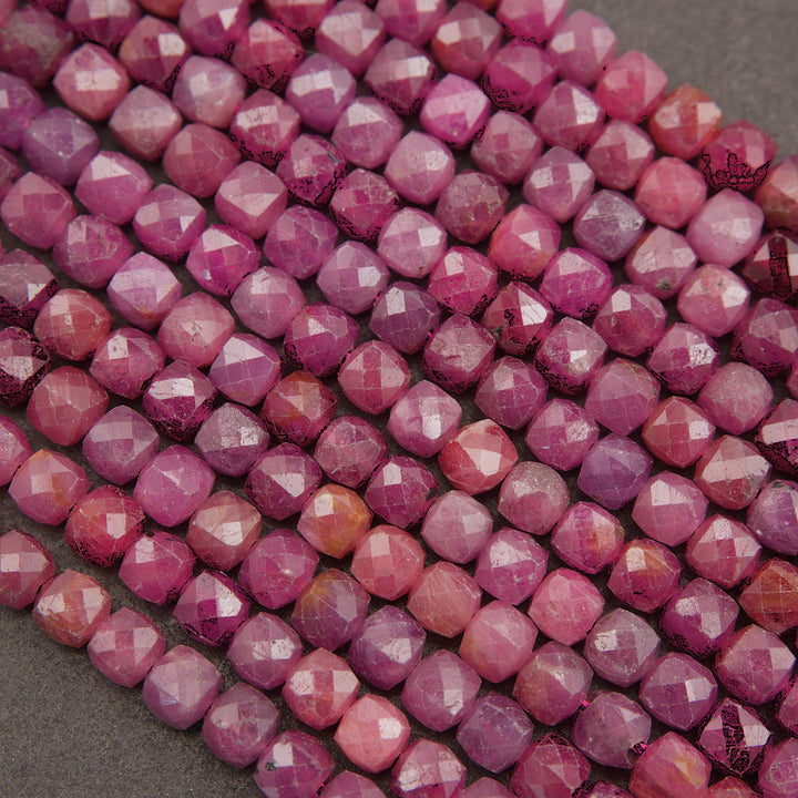 Faceted pink gemstone beads arranged in diagonal rows on a dark gray textured background.
