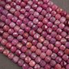 Faceted pink gemstone beads arranged in diagonal rows on a dark gray textured background.