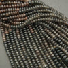 Close-up of dark blue beads on a gray surface
