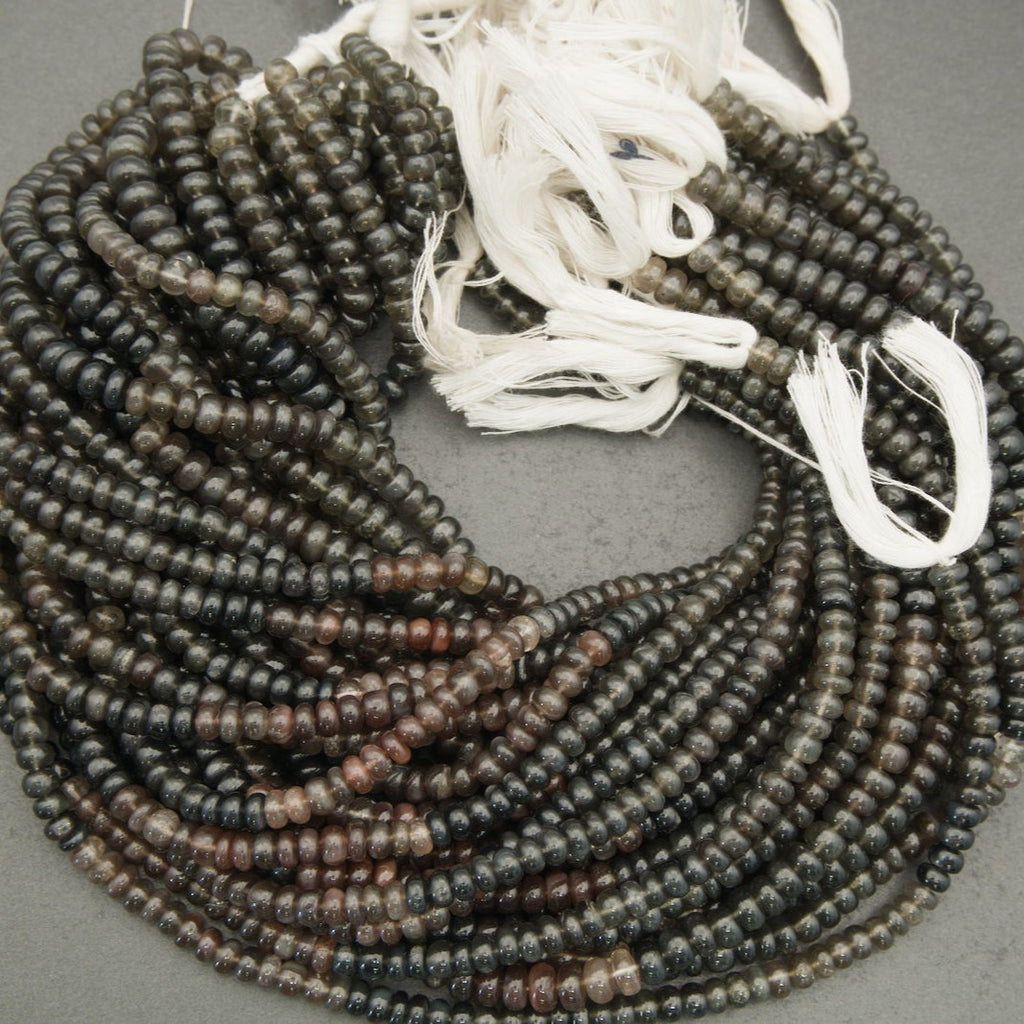 String of dark brown beads on a gray background