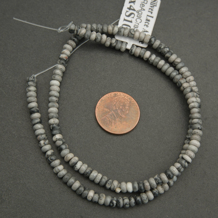 String of beads with a penny for scale on a gray background
