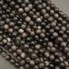 Close-up of dark brown pearls on a light gray background