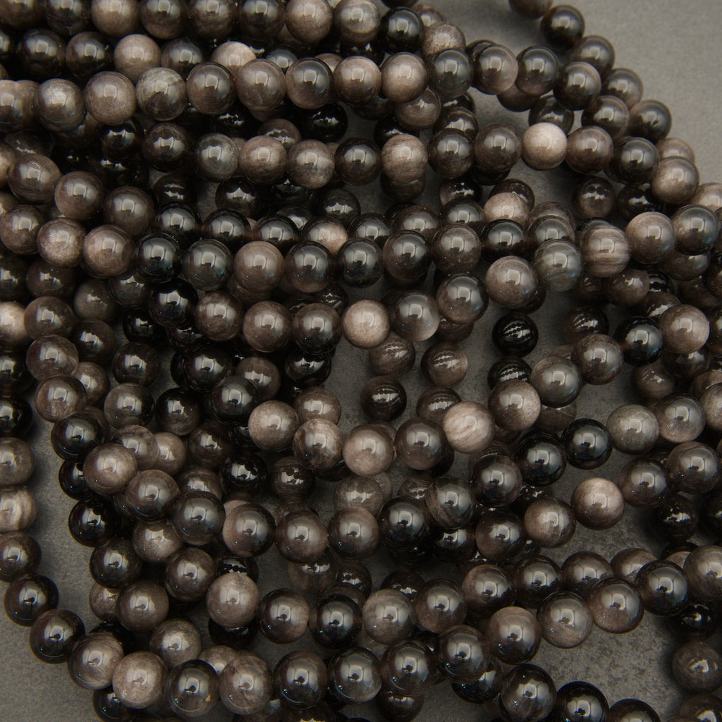 Close-up of a string of dark pearls on a neutral background