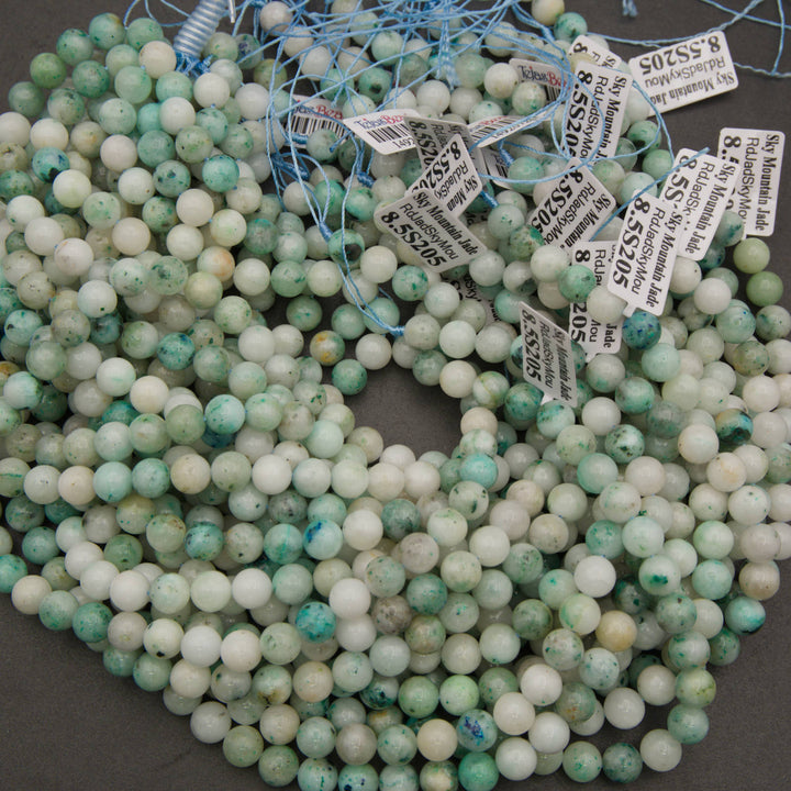 A bundle of smooth round Sky Mountain Jade bead strands with Tejas Beads tags