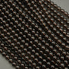 Close-up of dark brown metallic beads on a gray background