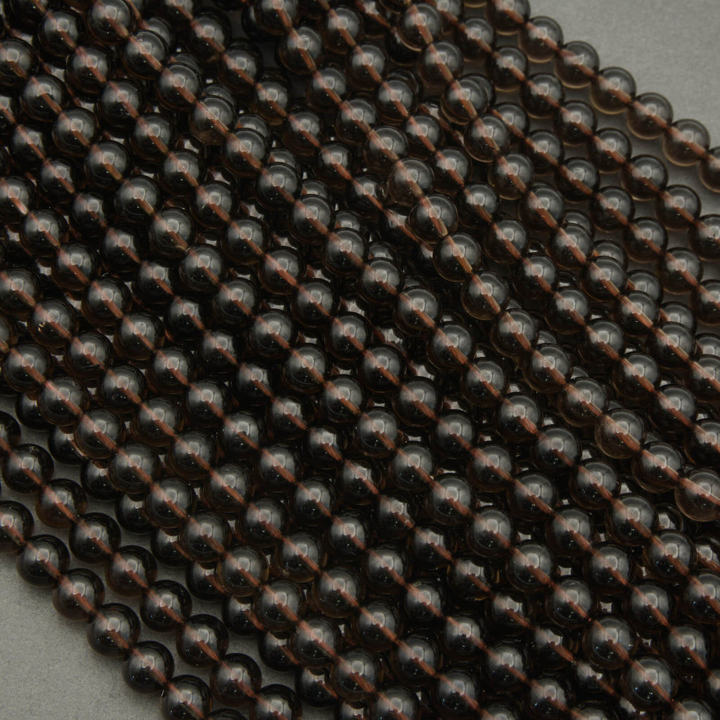 Close-up of dark brown metallic beads on a gray background