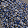 A heap of faceted snowflake sodalite star bead strands in royal blue with white patches and gold seed bead spacers