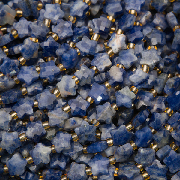 Close-up of faceted snowflake sodalite star beads showing blue and white patches and checkerboard facets