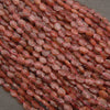 A heap of faceted strawberry quartz oval bead strands in soft pink to strawberry red