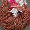 A bundle of faceted strawberry quartz oval bead strands with Tejas Beads tags