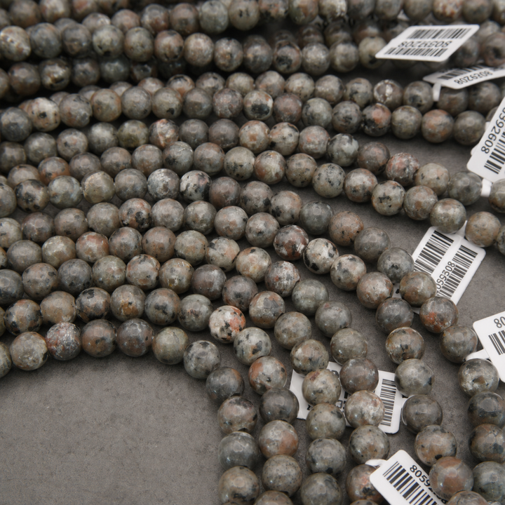 grey speckled beads on a string with large holes.
