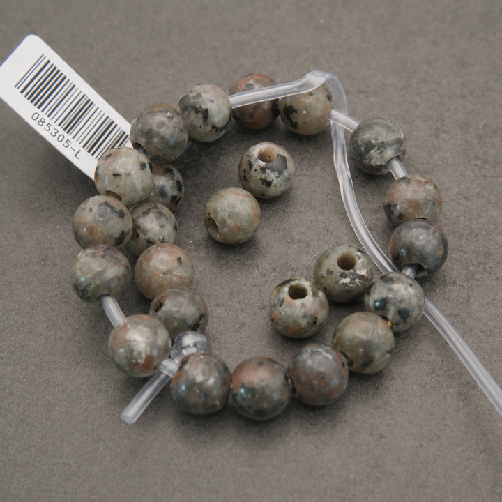 grey speckled beads on a string with large holes.
