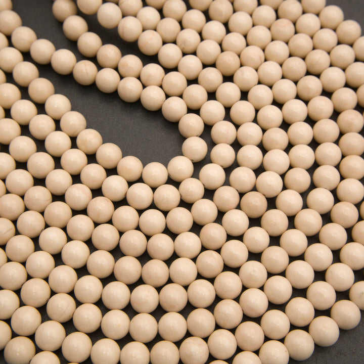 Beige wooden beads arranged in loops on a dark gray background.