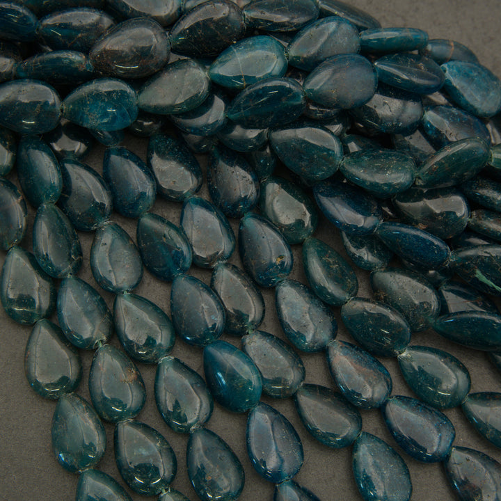 Teal teardrop-shaped beads on a gray background