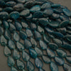 Teal teardrop-shaped beads on a gray background