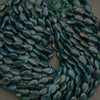 Close-up of dark blue pebbles on a gray surface