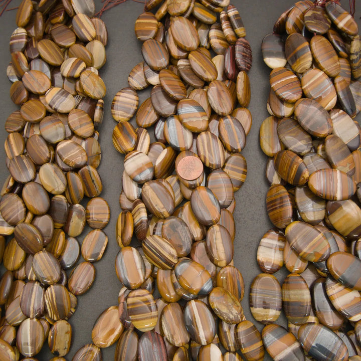 High-quality Tiger Iron oval beads showcasing rich brown, gray, cream, and reddish bands in a polished finish.