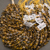 A bundle of faceted tiger's eye star bead strands with Tejas Beads tags