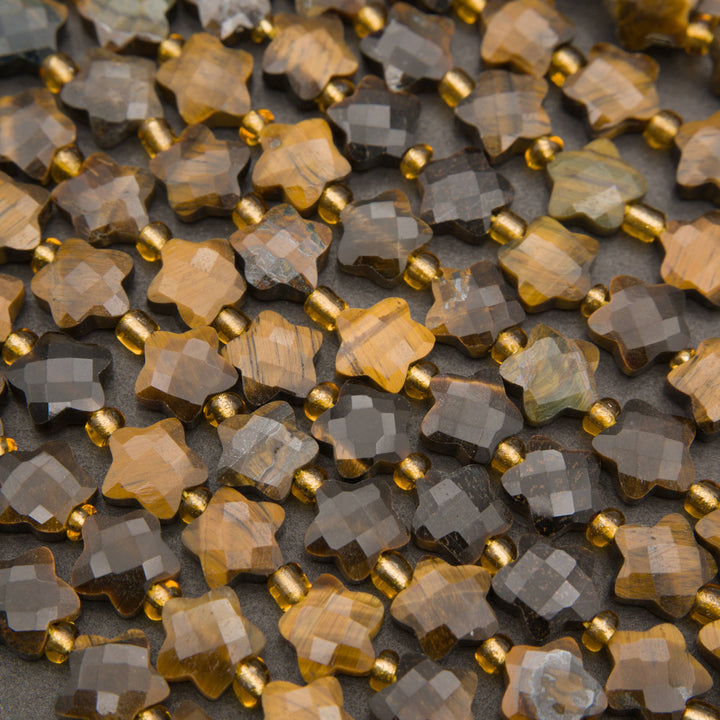 Rows of faceted tiger's eye star beads on a gray background in honey, caramel and chocolate