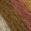 Close-up of multicolored beaded fabric with brown, pink, and beige tones.