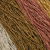 Close-up of multicolored beaded fabric with brown, pink, and beige tones.