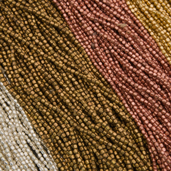 Close-up of multicolored beaded fabric with brown, pink, and beige tones.