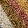 Close-up of multicolored beaded fabric with brown, pink, and beige tones.