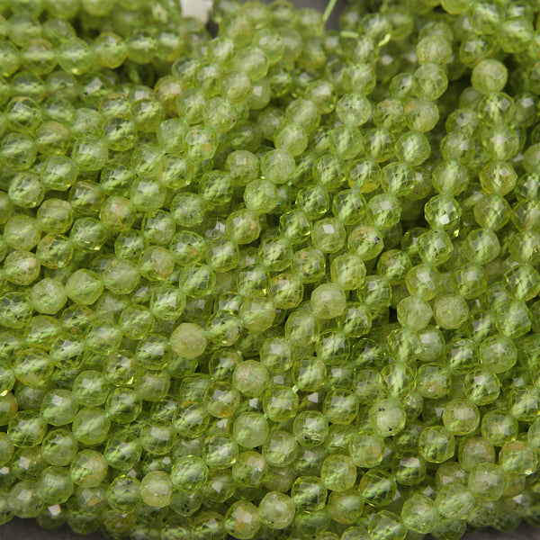 A close-up pile of faceted round beads in a translucent light green color, showing a textured, honeycomb-like surface.