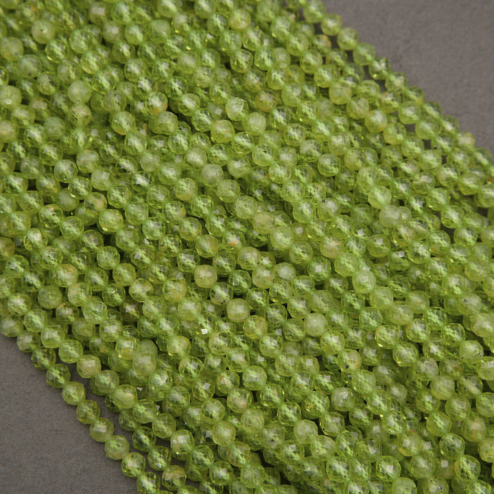 Green faceted round beads arranged in diagonal rows on a dark gray background.