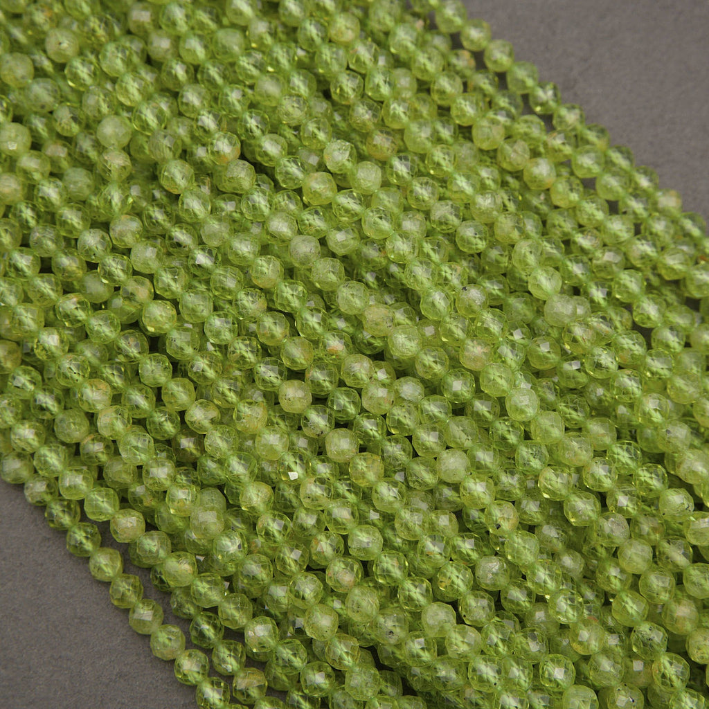Green faceted round beads arranged in diagonal rows on a dark gray background.