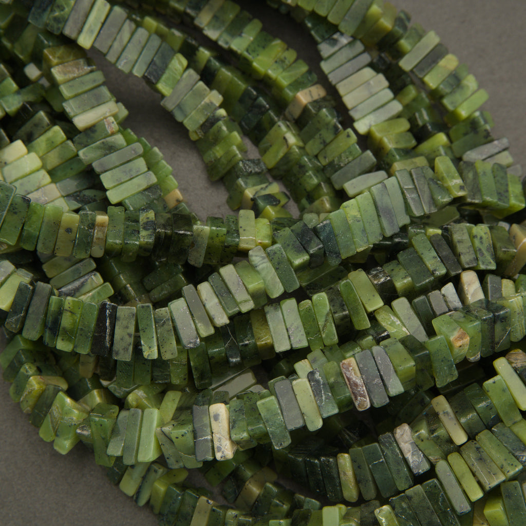 Close-up of a string of green beads on a gray background