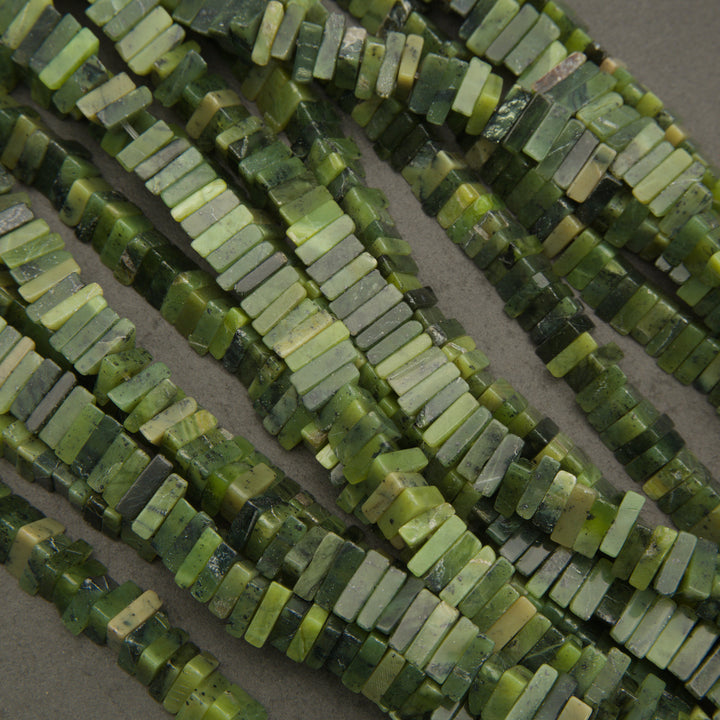 Close-up of green beaded strands on a neutral background