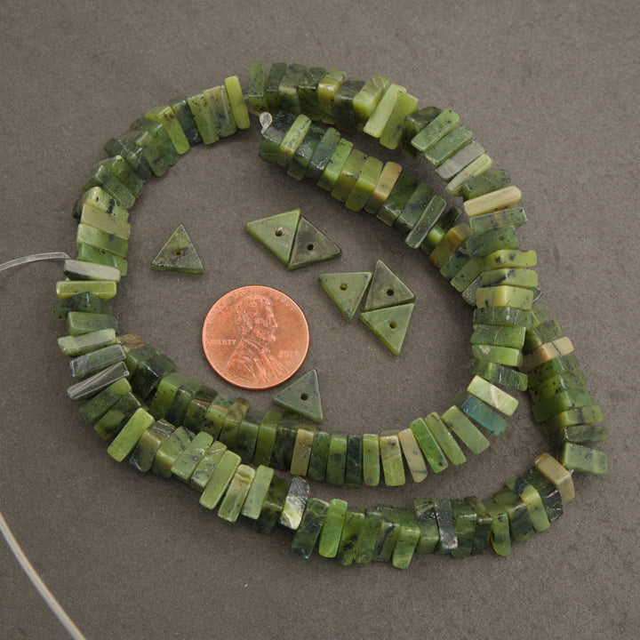 Green bead necklace with a penny for scale on a gray background
