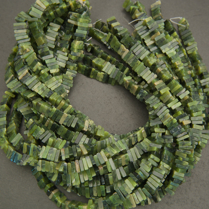 Green beaded necklace on a gray background