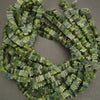 Green beaded necklace on a gray background