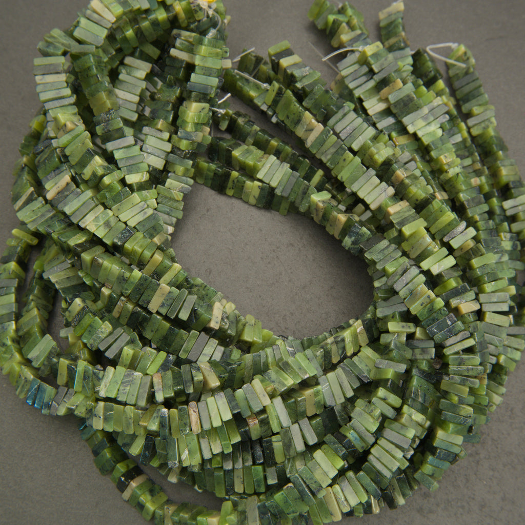 Green beaded necklace on a gray background