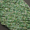Strands of microfaceted variscite beads in soft green and cream on a gray background