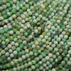 Close-up of microfaceted round variscite beads in soft green, mint and cream with dark matrix