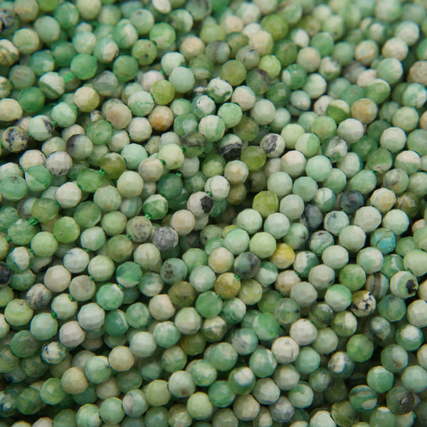 Close-up of microfaceted round variscite beads in soft green, mint and cream with dark matrix