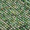 Close-up of microfaceted variscite beads showing mint green, cream and dark matrix spots