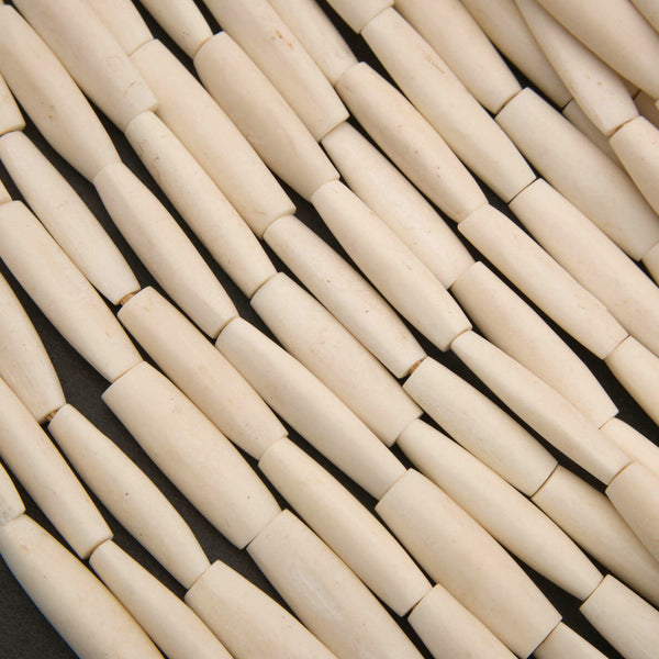 Ivory colored elongate tube shape beads.