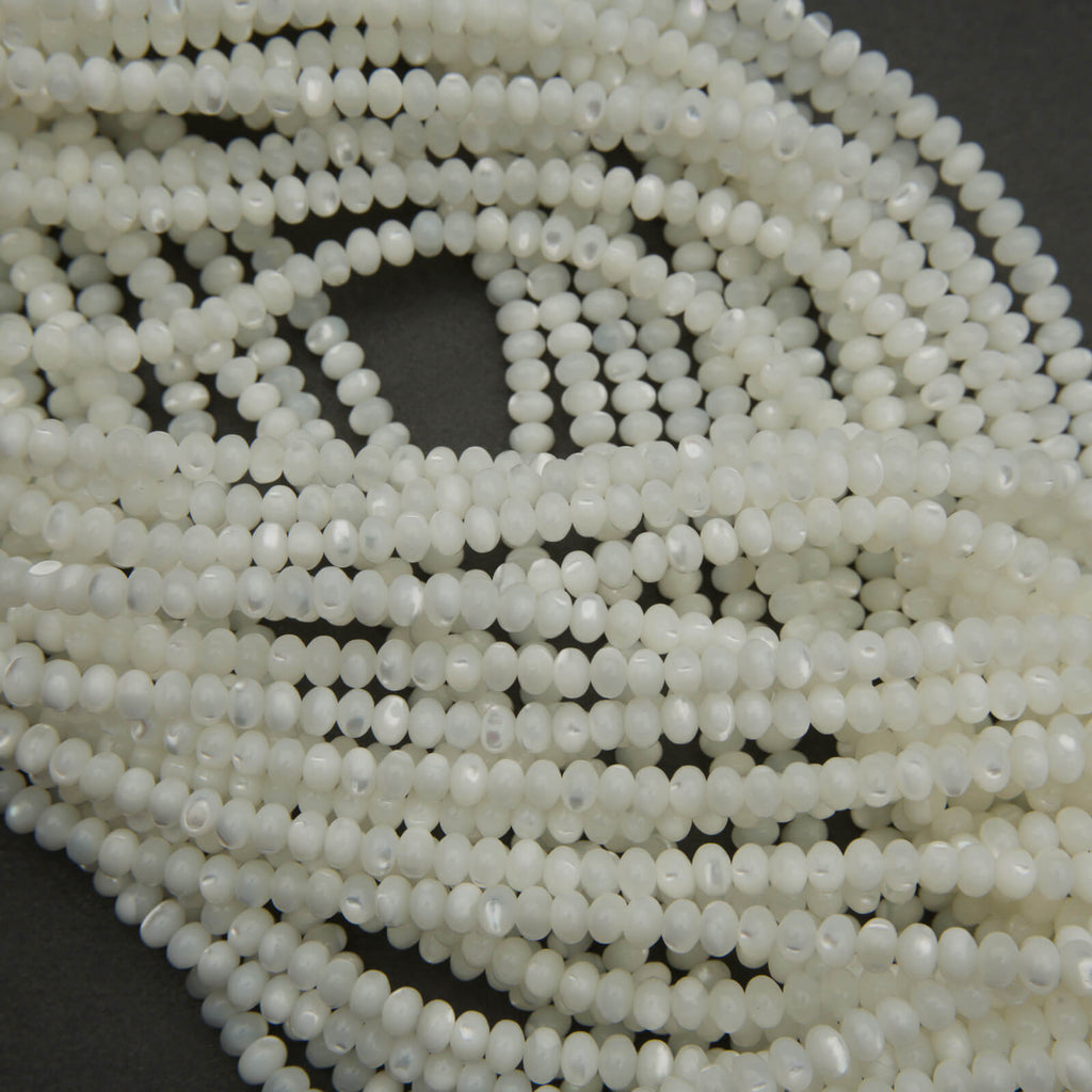 Close-up of a string of white beads on a dark background