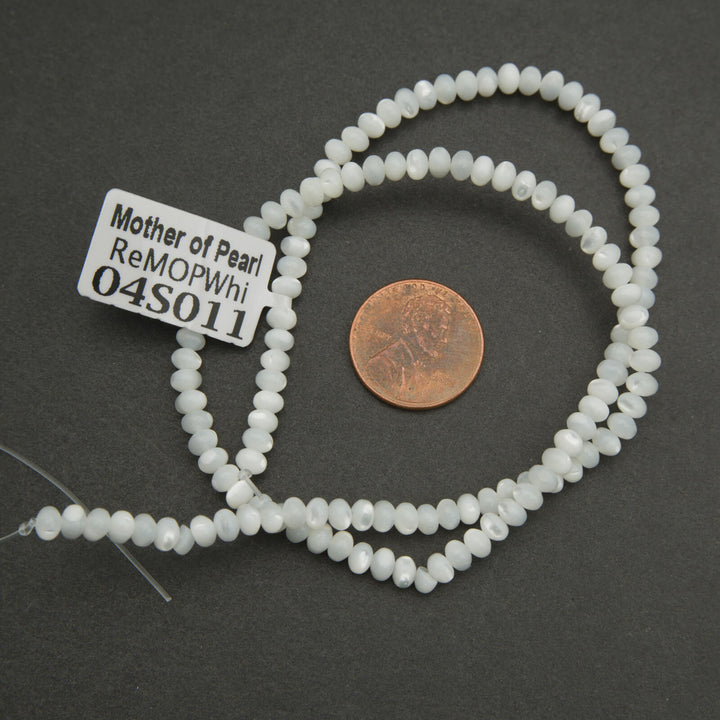 String of white beads with a label on a dark surface