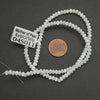 String of white beads with a label on a dark surface
