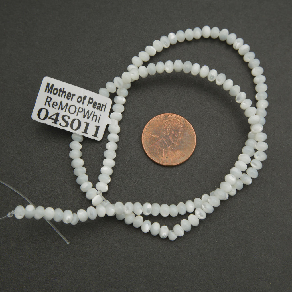 String of white beads with a label on a dark surface