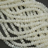 Close-up of white seed beads on a dark background