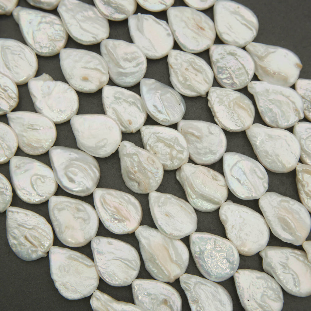 White teardrop-shaped beads on a dark background