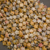 A heap of faceted yellow crazy lace agate star bead strands in cream, mustard, gray and coral with gold seed bead spacers