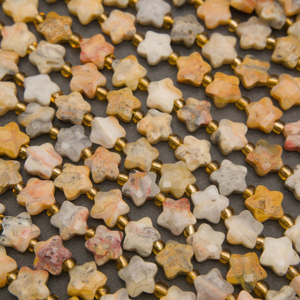Close-up of faceted yellow crazy lace agate star beads showing lace banding in cream, yellow and coral
